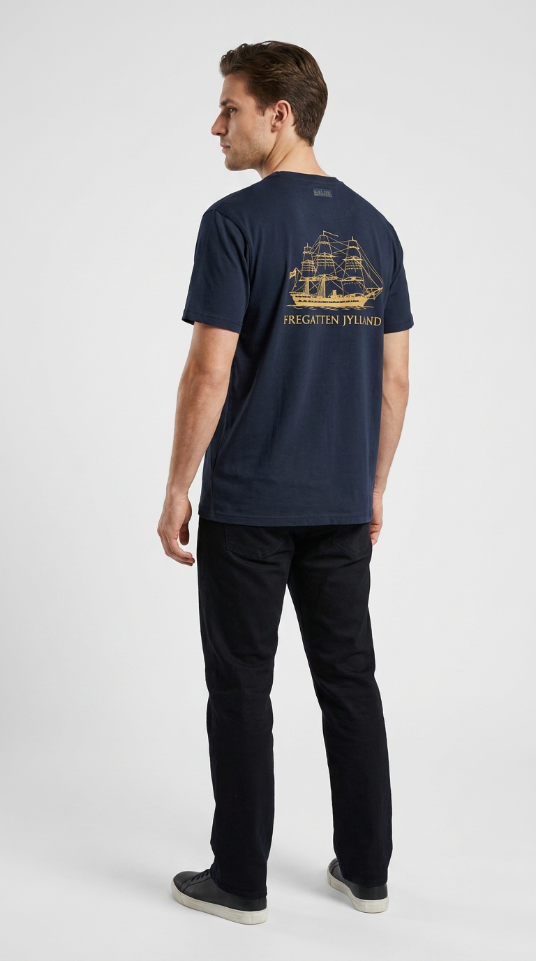 Mand set bagfra i mørkeblå t-shirt med guldprint af Fregatten Jylland på ryggen.