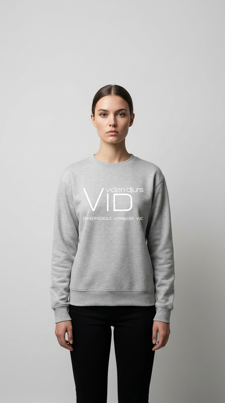 Kvinde i grå Viden Djurs sweatshirt og sorte bukser foran en lys grå baggrund.