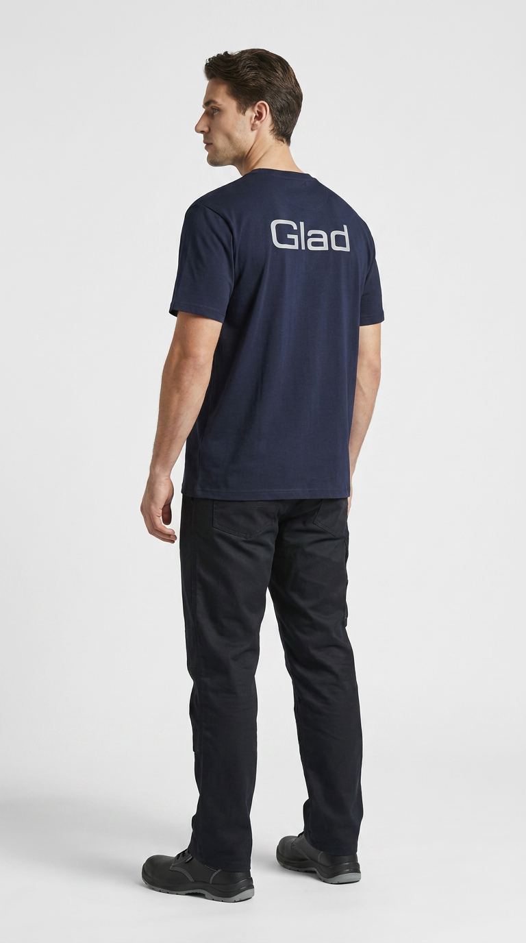Mand set bagfra i en mørkeblå t-shirt med teksten "Glad" på ryggen og sorte bukser.