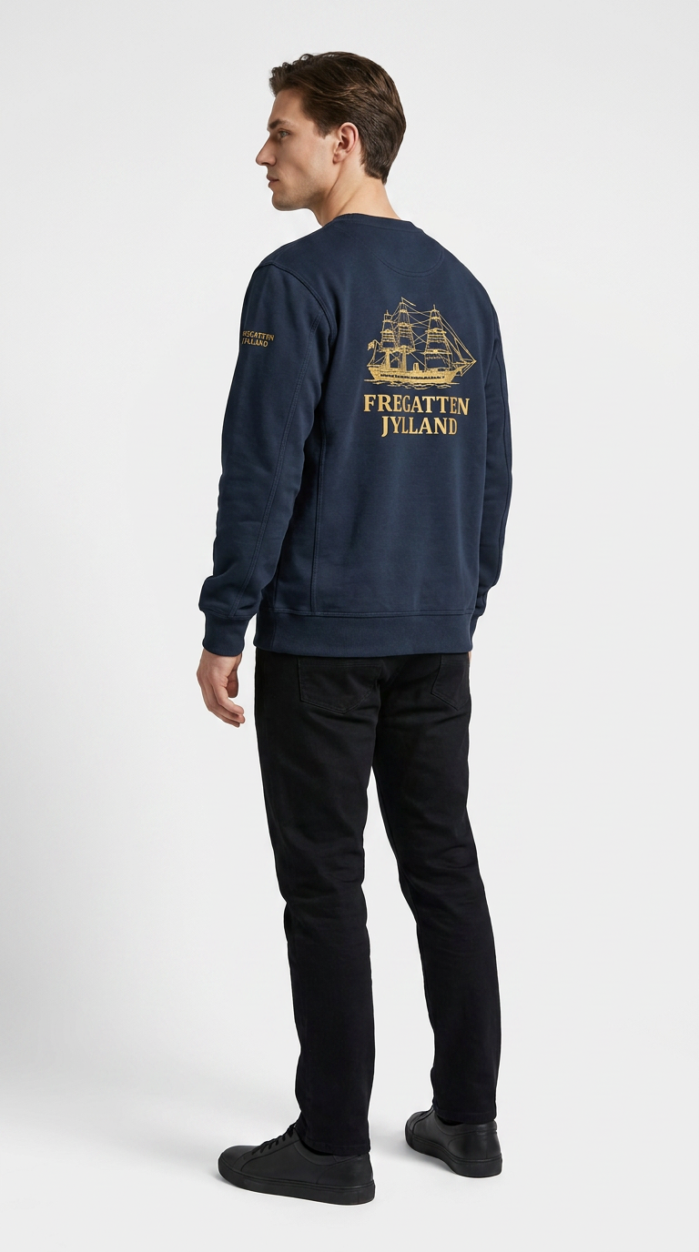 Mand set bagfra i mørkeblå sweatshirt med guldtryk af Fregatten Jylland på ryggen.