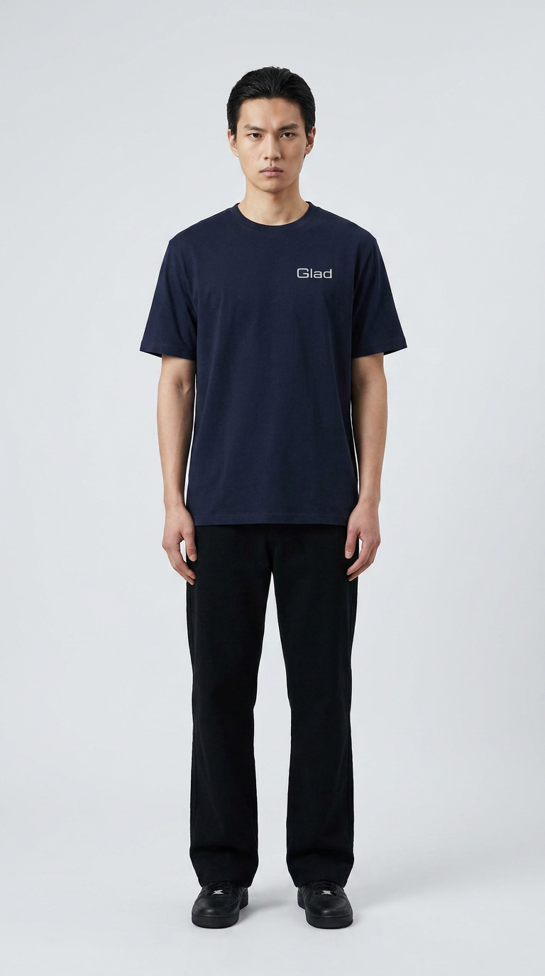 Mand i mørkeblå t-shirt med Glad-logo og sorte bukser mod en lys baggrund.