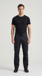 Mand i sort t-shirt og sorte arbejdsbukser stående mod en lys baggrund.