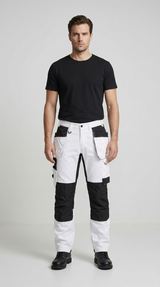 Mand i sort t-shirt og hvide arbejdsbukser med sorte detaljer mod en lys baggrund.
