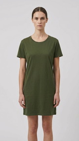 Kvinde iført en kortærmet olivengrøn T-shirt-kjole mod en lys grå baggrund.