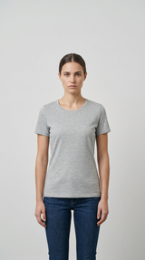 Kvinde iført en grå kortærmet t-shirt og blå jeans mod en neutral baggrund.