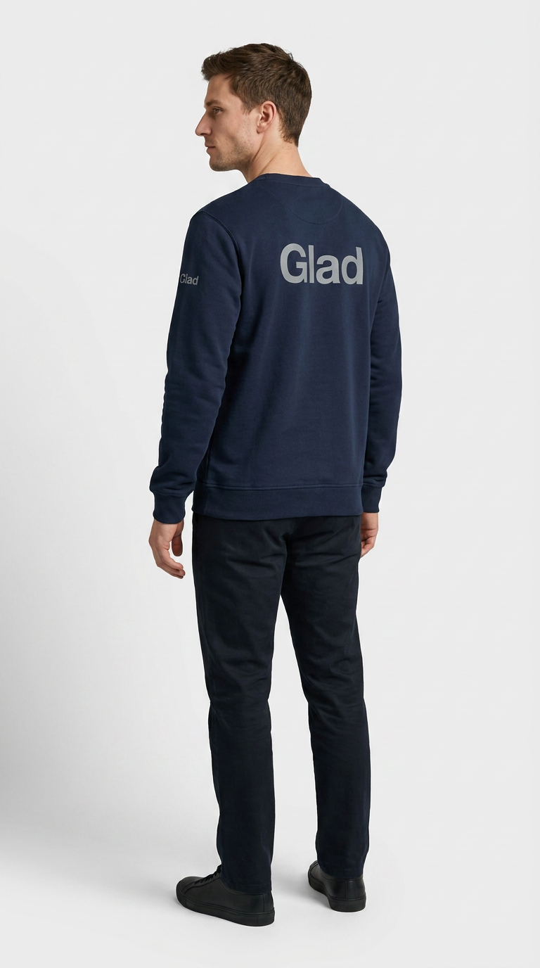 Mand set bagfra i en mørkeblå sweatshirt med "Glad" tekst på ryggen og mørke bukser.