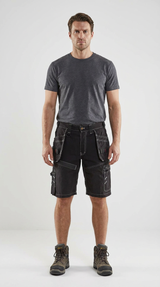 Mand iført grå t-shirt, sorte arbejdsshorts med hvide syninger og brune arbejdsstøvler på hvid baggrund.