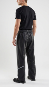 Mand set bagfra iført sort t-shirt og sorte regnbukser med refleksdetaljer mod en hvid baggrund.