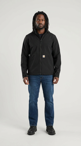 Mand med dreadlocks iført en sort Carhartt-jakke og blå jeans mod en lys grå baggrund.