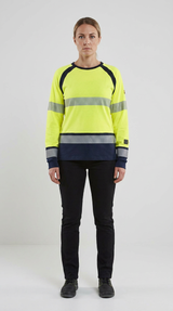 Kvinde i gul og mørkeblå high-vis sweatshirt med refleksstriber og sorte arbejdsbukser.