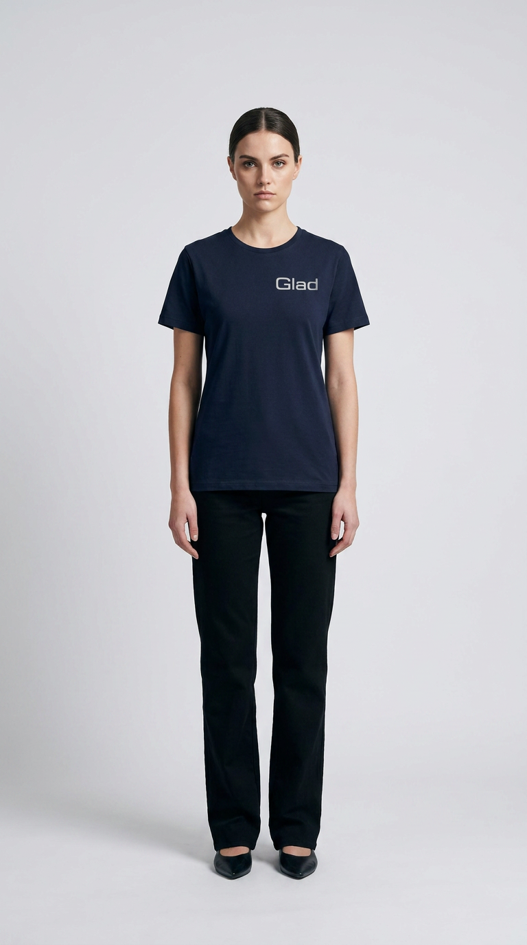 Kvinde i mørkeblå t-shirt med 'Glad' logo og sorte bukser på en lys baggrund.