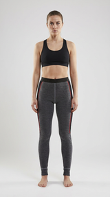 Kvinde i sort sports-bh og grå leggings med røde striber mod en lys baggrund.