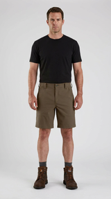 Mand i sort t-shirt, olivengrønne shorts og brune arbejdsstøvler mod en hvid baggrund.