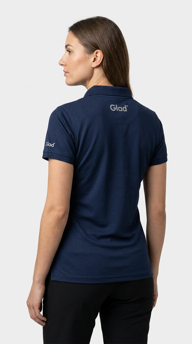 Kvinde set bagfra i en mørkeblå polo med Glad-logo på ryggen og ærmet mod en hvid baggrund.