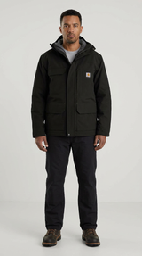 Mand i sort Carhartt-jakke med hætte, sorte bukser og brune støvler mod en lys baggrund.