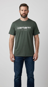 Mand med skæg i en mørkegrøn Carhartt t-shirt og blå jeans på en hvid baggrund.