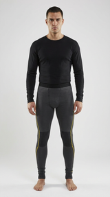 Mand i sort langærmet trøje og grå leggings med gule striber og sorte knæpaneler på hvid baggrund.