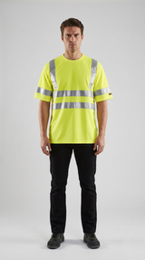 Mand i en neongul t-shirt med refleksstriber og sorte bukser mod en grå baggrund.