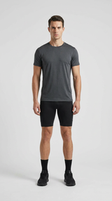Mand i mørkegrå t-shirt og sorte sportsshorts stående mod en hvid baggrund.