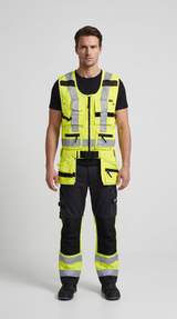 Mand i gul high-vis vest med lommer og matchende arbejdsbukser med reflekser på en lys baggrund.