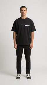 Mand i sort t-shirt med lyserødt stjernelogo og sorte bukser mod en hvid baggrund.
