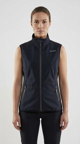 Kvinde iført en mørkeblå Blåkläder softshell-vest med høj krave og lynlåslommer på en lys baggrund.