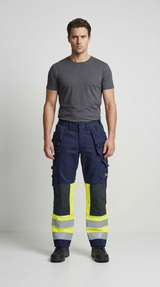 Mand i grå t-shirt og mørkeblå arbejdsbukser med gule high-vis detaljer og reflekser.