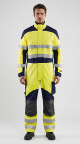 Mand i gul og mørkeblå high-visibility heldragt med refleksstriber mod en grå baggrund.