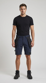 Mand iført sort t-shirt, mørkeblå arbejdsshorts og sorte støvler mod en lys baggrund.