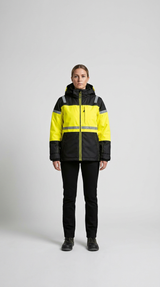 Kvinde i gul og sort high-visibility vinterjakke med reflekser, sorte bukser og arbejdsstøvler.