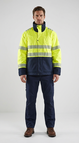Mand i gul og mørkeblå high-visibility arbejdsjakke med reflekser og mørkeblå arbejdsbukser.