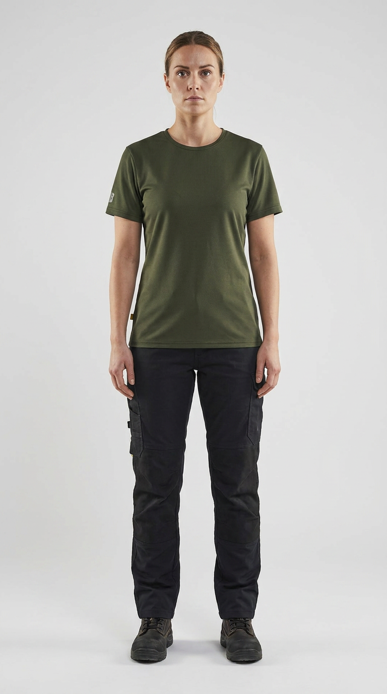 Kvinde i olivengrøn t-shirt og sorte arbejdsbukser på en hvid baggrund.