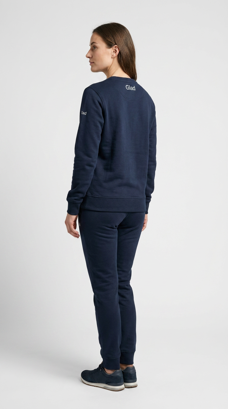 Kvinde set bagfra i mørkeblåt joggingtøj med Glad-logo mod en hvid baggrund.