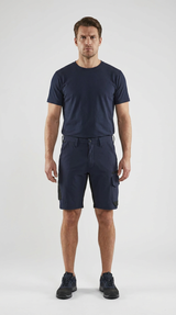 Mand i mørkeblå t-shirt og cargoshorts mod en hvid baggrund.