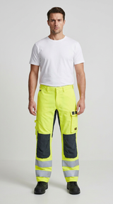 Mand i hvid t-shirt og neongule arbejdsbukser med refleksstriber og knæpuder.