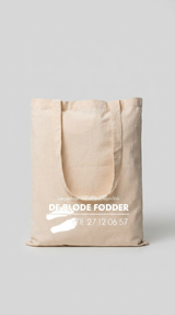 Beige mulepose med hvidt logo for fodplejeklinikken De Bløde Fødder på en lys baggrund.
