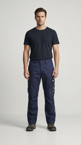 Mand iført sort t-shirt og mørkeblå arbejdsbukser med cargolommer og støvler mod en lys baggrund.