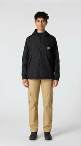 Kvinde i sort Carhartt-jakke med hætte og beige cargobukser foran en hvid baggrund.