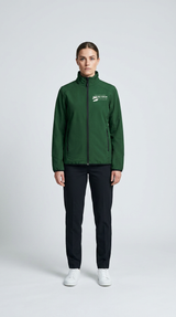 Kvinde iført en grøn softshell-jakke med logo, sorte bukser og hvide sneakers mod en lys baggrund.