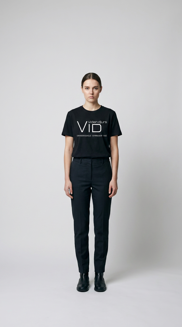 Kvinde i sort VID viden djurs t-shirt og mørke bukser mod en lys baggrund.