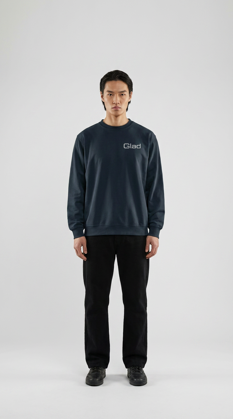 Mand i mørkeblå sweatshirt med Glad-logo og sorte bukser mod en lys baggrund.