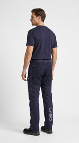 Mand i mørkeblå arbejds-t-shirt og bukser med logo, set bagfra mod en hvid baggrund.