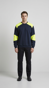 Mand i mørkeblå sweatshirt med neon-gule detaljer og sorte bukser mod en lys baggrund.
