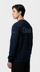 Mand i mørkeblå sweatshirt med 'Glad' logo på ryggen og ærmet mod en hvid baggrund.
