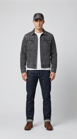 Mand iført grå denimjakke, hvid t-shirt, mørkeblå jeans, brune støvler og en grå kasket.
