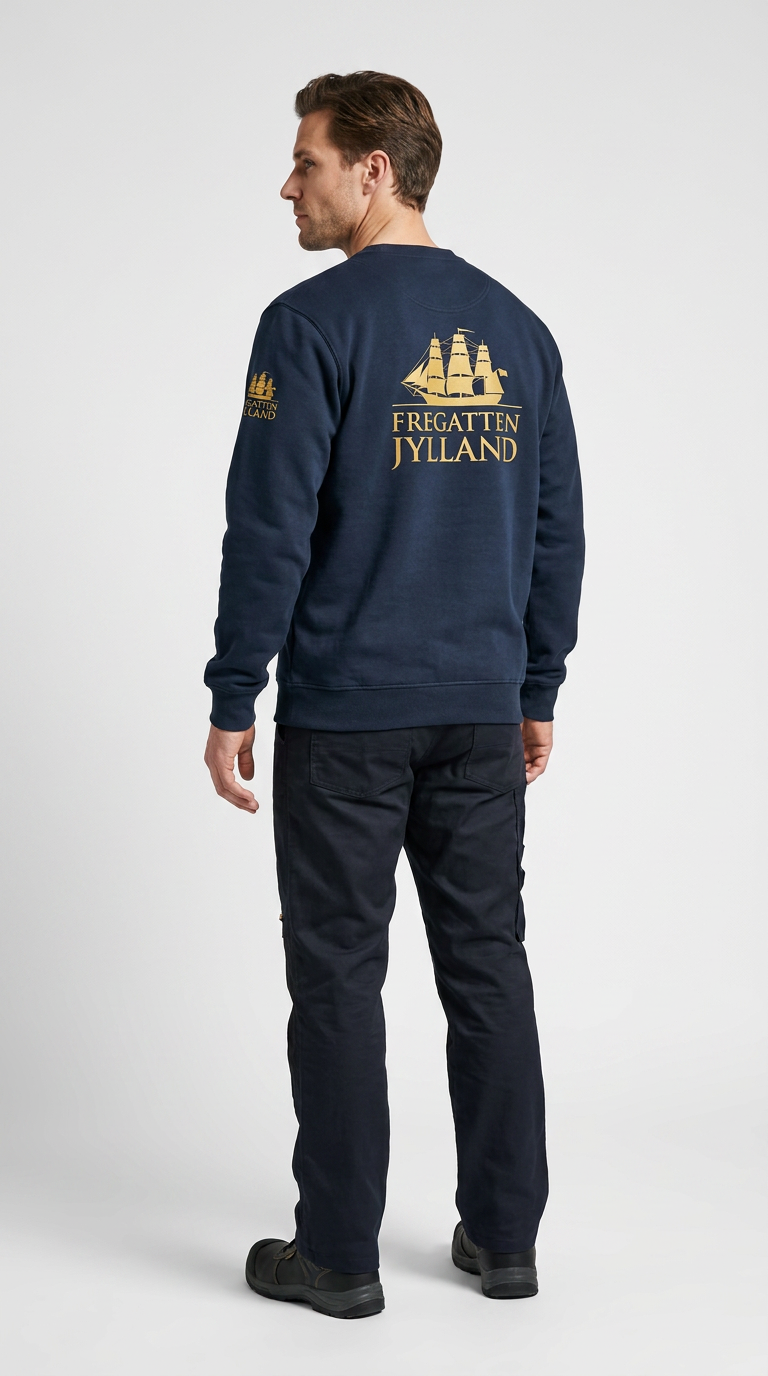 Mand set bagfra i mørkeblå sweatshirt med guldlogo af Fregatten Jylland og mørke bukser.
