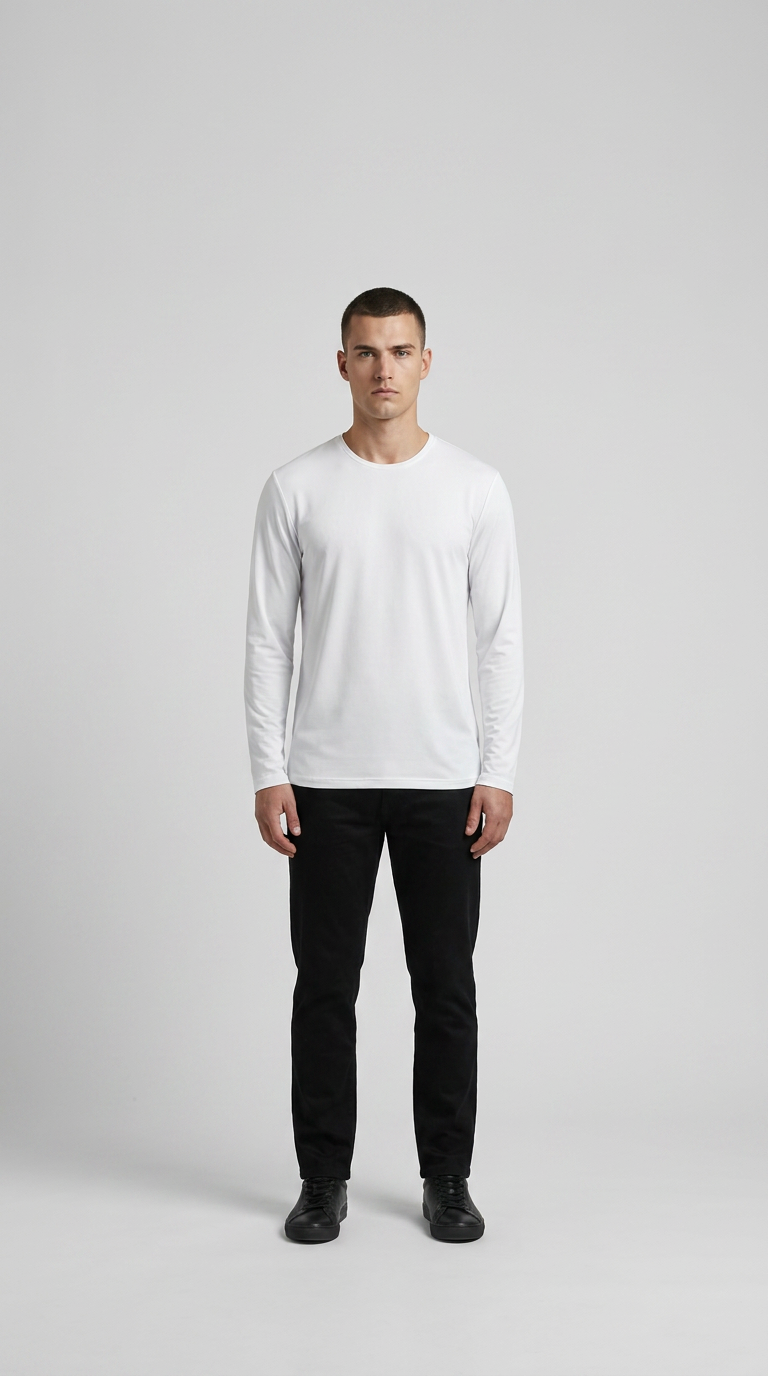Mand i hvid langærmet t-shirt og sorte bukser mod en lys grå baggrund.