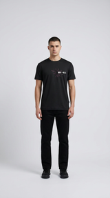 Mand i sort t-shirt med grafisk "BI + LL" logo og sorte bukser på en lys baggrund.