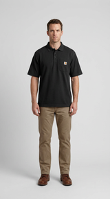 Mand i sort Carhartt poloshirt og khaki bukser stående mod en lys grå baggrund.