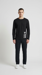 Mand i sort langærmet t-shirt med hvidt 'DRONE WORX' logo og sorte bukser på en hvid baggrund.